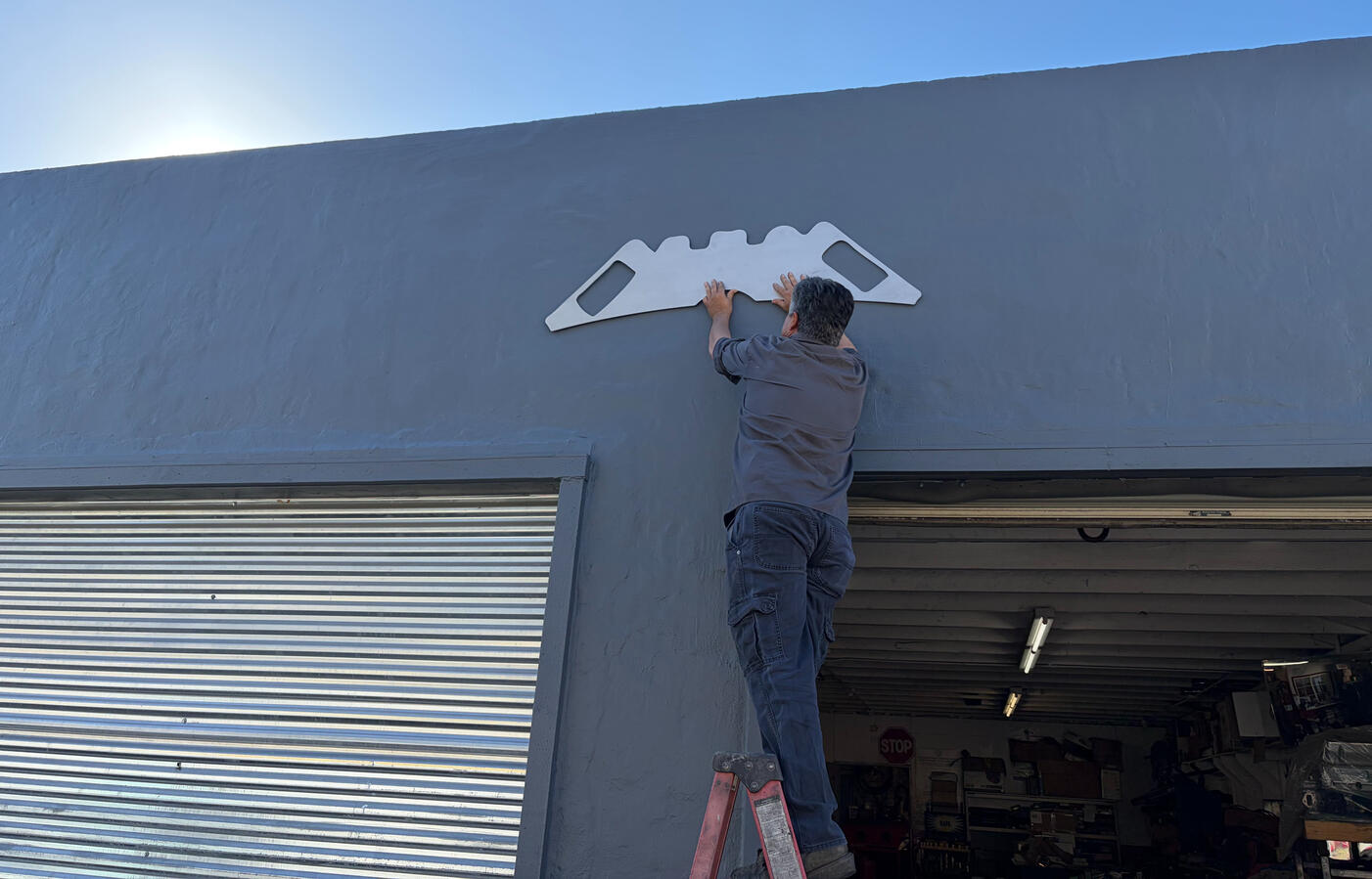 Photo of a man measuring a painted wall.